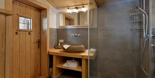 Das Bad besticht durch ein geschmackvolles Ambiente. Hotel Almhof Skigebiet Hochfügen Badezimmer Zillertal Hotelzimmerausstattung